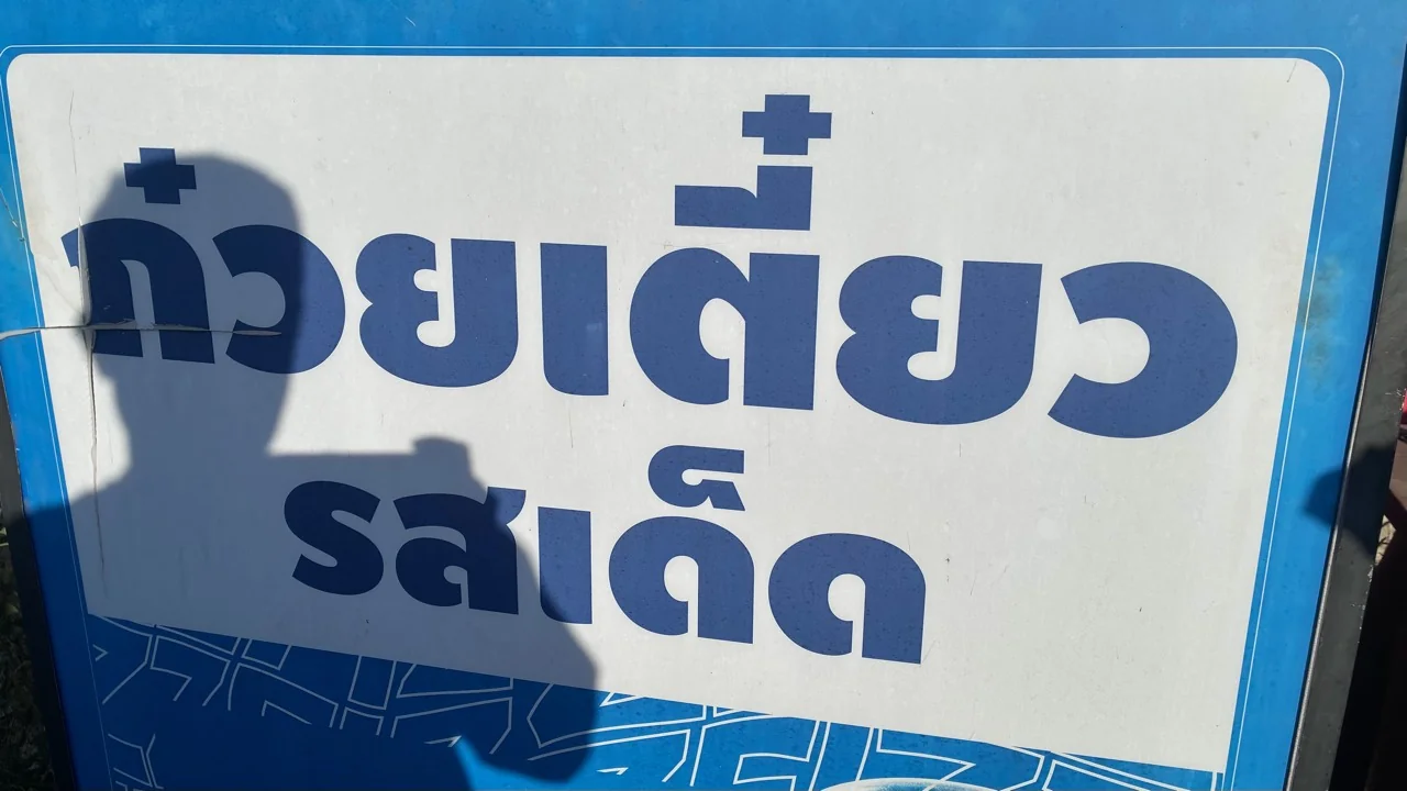 ป้ายร้านก๋วยเตี๋ยวรสเด็ด ตัวอักษรสีน้ำเงินบนพื้นขาว